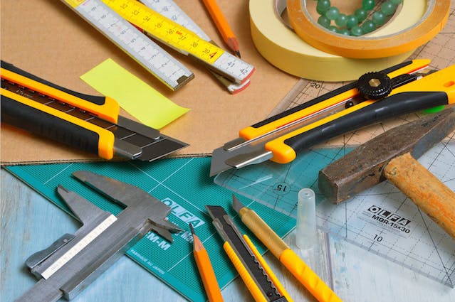 a bunch of tools and tape measures on a work station